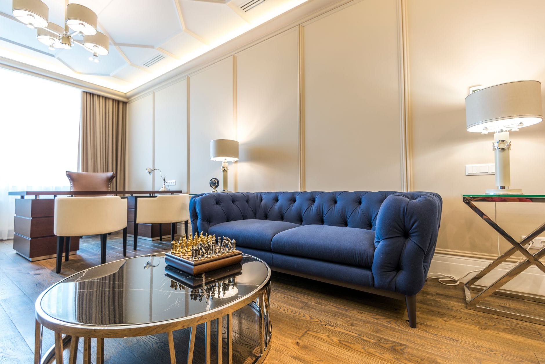 Nowoczesny jasny salon z niebieską sofą i eleganckimi dodatkami