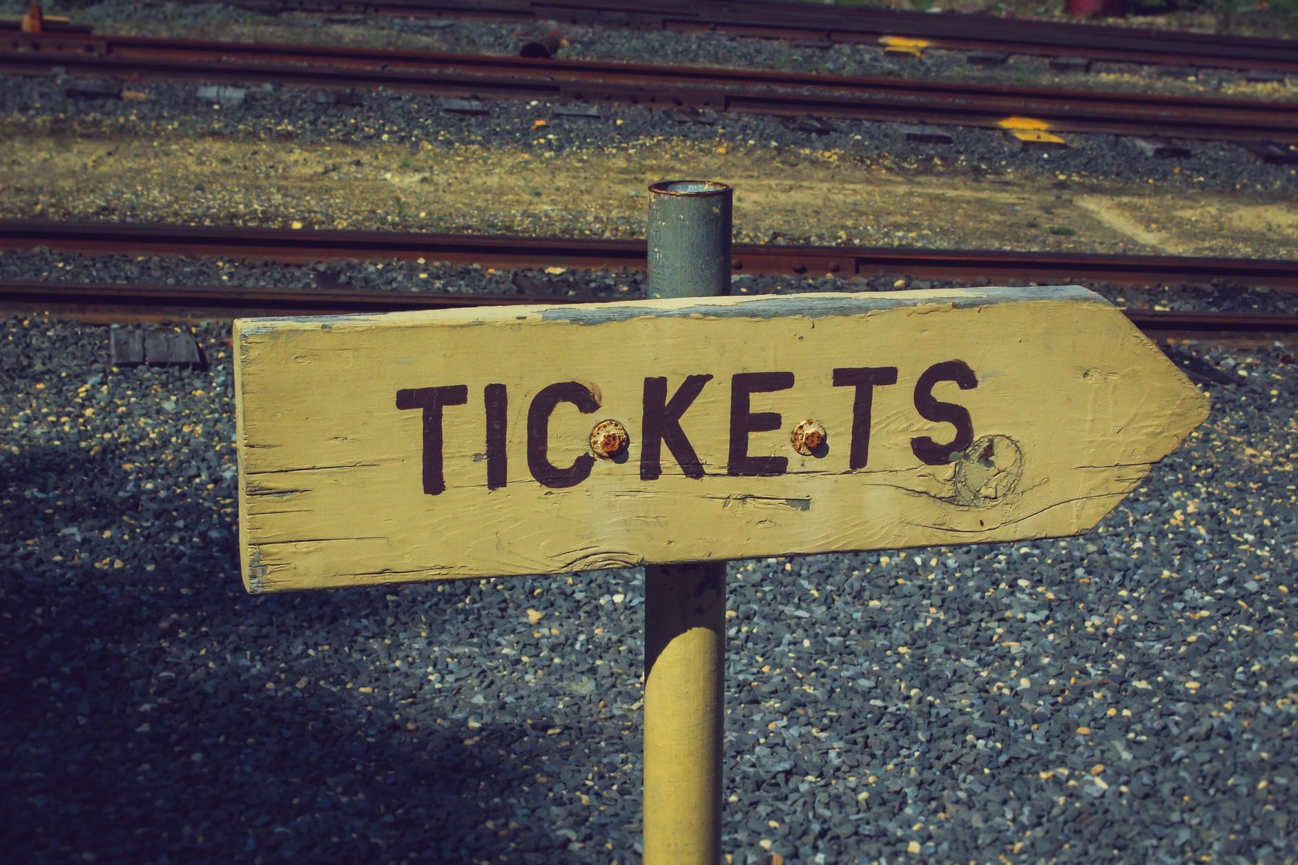 Drewniany szyld ticket przy torach kolejowych w stylu vintage