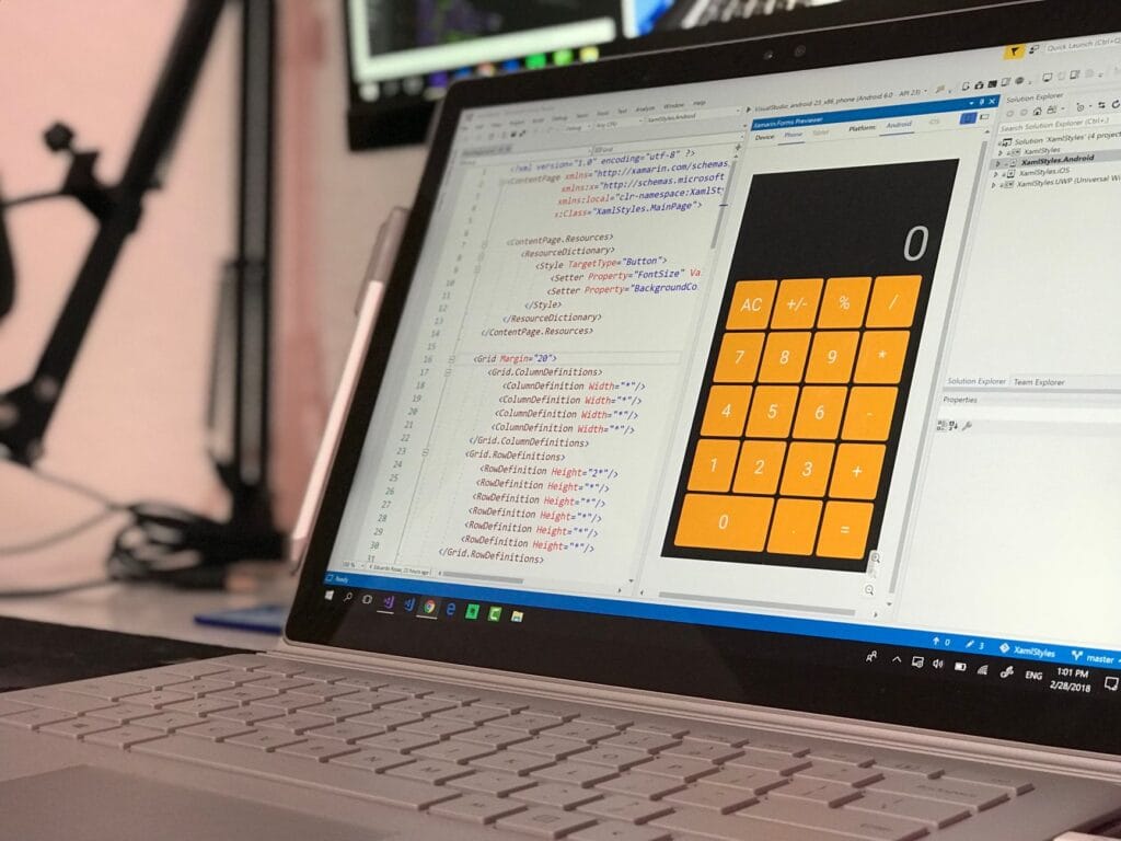 Ekran laptopa z aplikacją do programowania i projektem kalkulatora