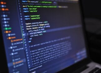 Jak dodać własną funkcję AI do Google Sheets w Apps Script Zbliżenie ekranu komputera z kodem programistycznym w ciemnym otoczeniu